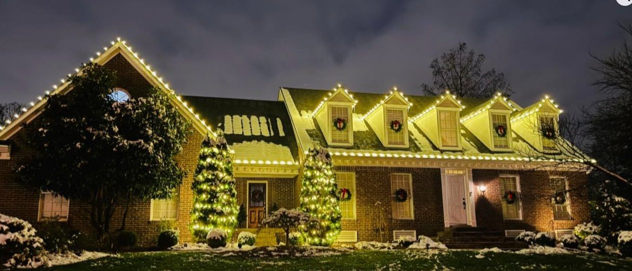 snow covered home with Christmas lights, wreaths and wrapped trees Louisville KY