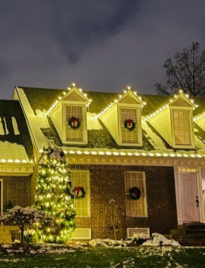 christmas light installation snow covered home