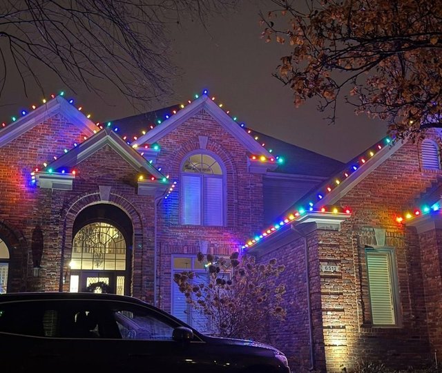multicolor Christmas lights on a two-story brick home Louisville KY
